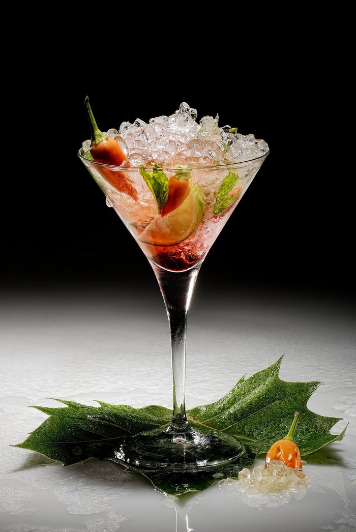 Cocktail with chili pepper and lime in martini glass