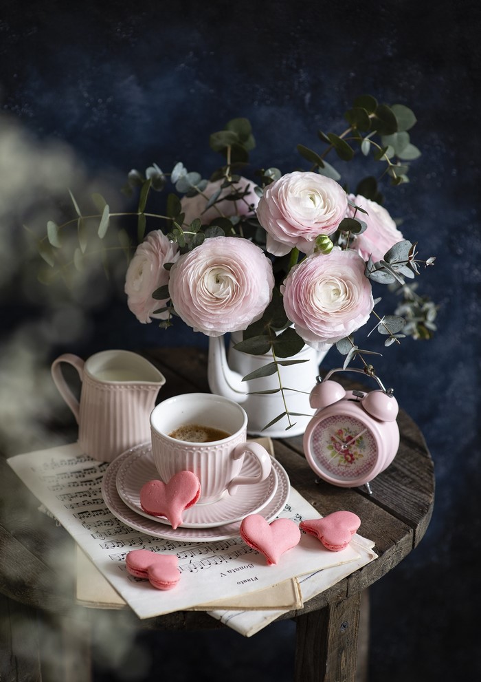 Still life with pink flowers, coffee, and heart cookies