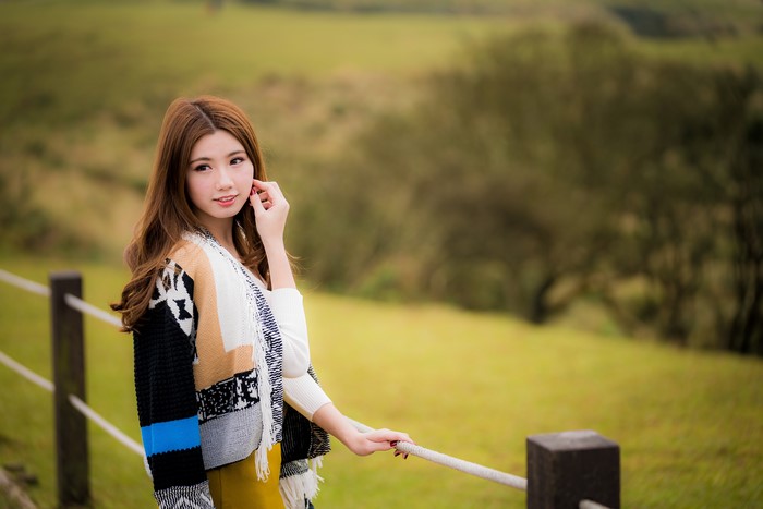 Beautiful Asian woman with brown hair in a colorful cardigan