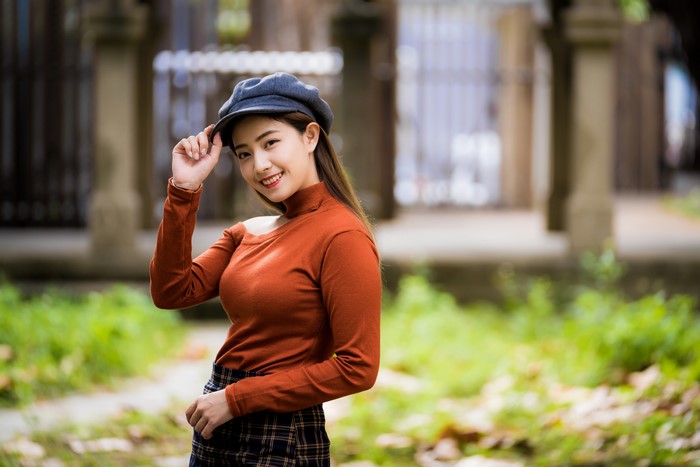 Asian woman in sweater and hat smiling