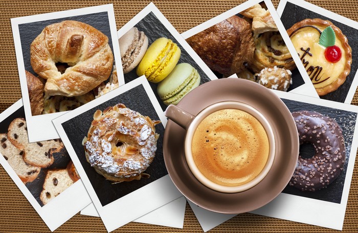 Coffee cup with assorted pastries and macarons