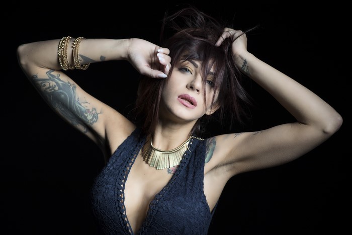 Woman with tattoos and jewelry posing