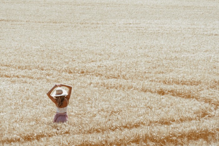 Woman in a straw hat in a wheat field