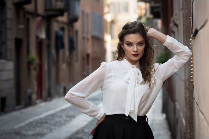 Woman in white blouse and black skirt posing