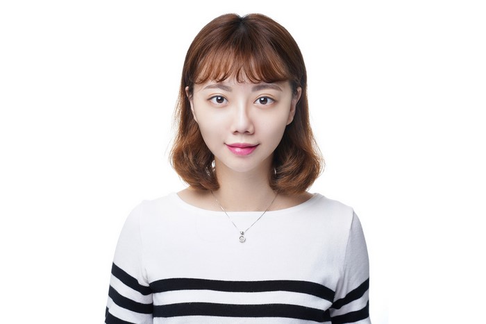 Asian woman with brown hair wearing a sweater