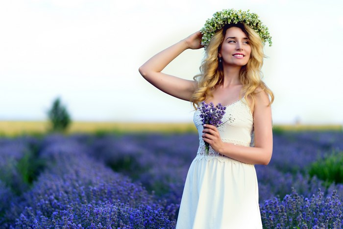 Blonde girl with flower wreath in lavender field