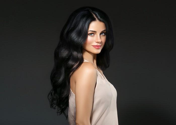 Brunette woman with wavy black hair and makeup