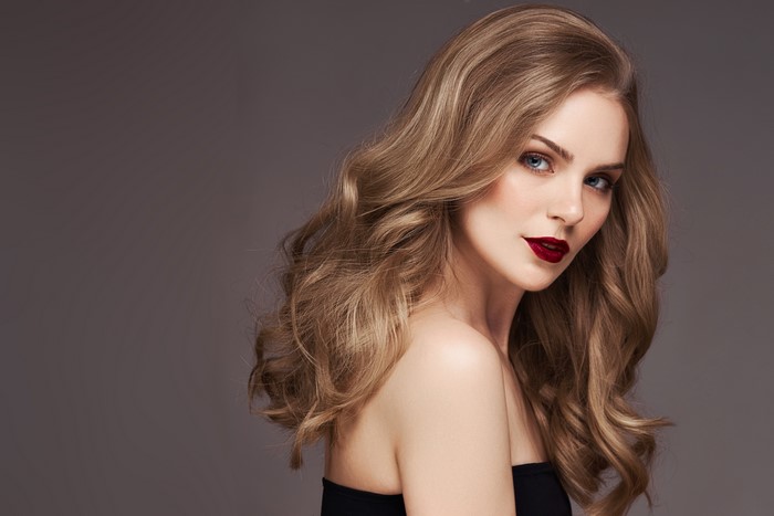 Beautiful woman with blonde wavy hair and dark red lipstick