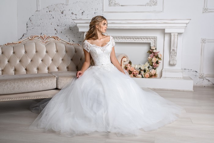 Bride in a white wedding dress sitting on a couch