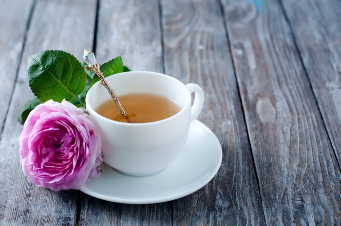Tea in a cup with a rose and spoon