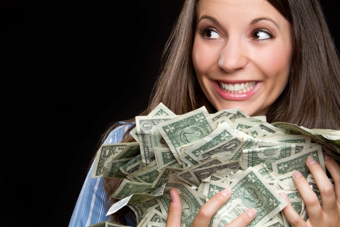 Woman Holding a Large Pile of Money