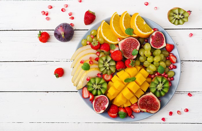 Fruit platter with kiwi, grapes, oranges, mango, figs, and strawberries