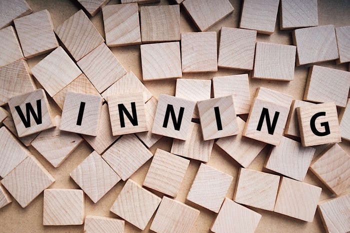Wooden letter tiles spelling out WINNING