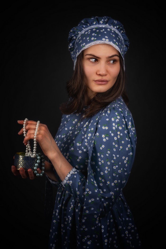 Woman in floral dress holding pearls