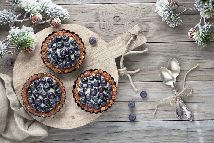 Blueberry tarts on a cutting board with spoons