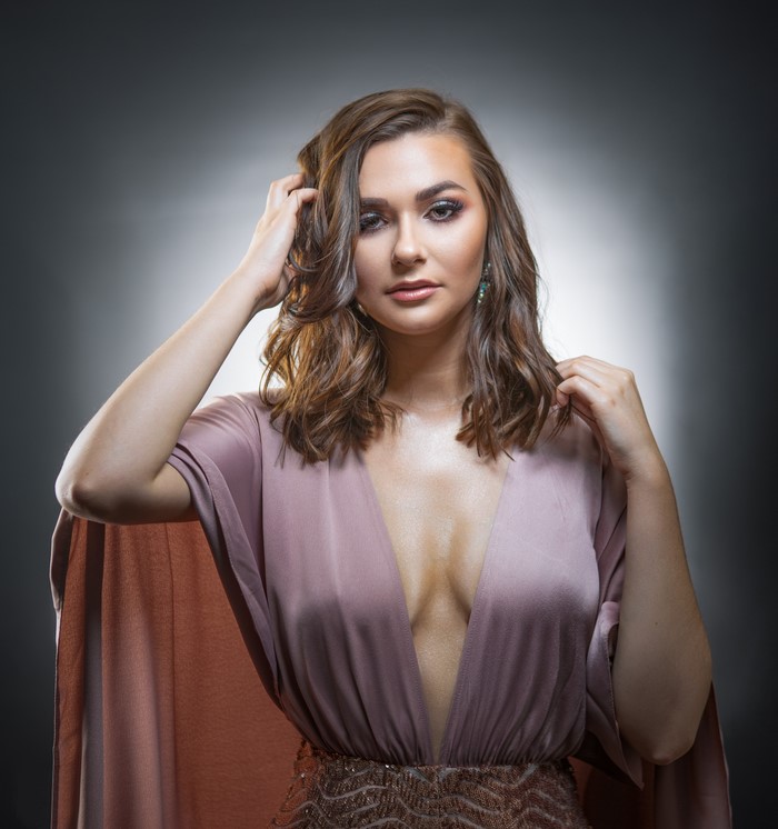 Woman in a pink dress with hands in hair