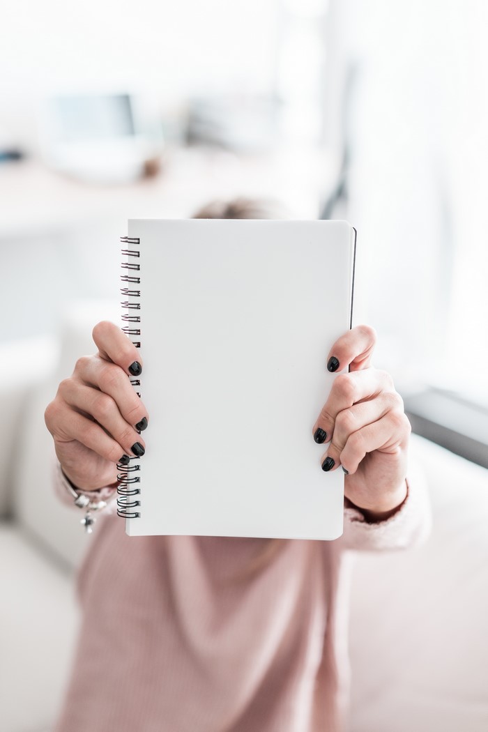 Woman holding a blank notebook