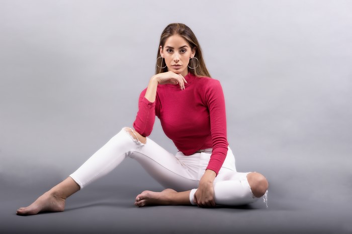 Brenda sitting in ripped jeans and sweater