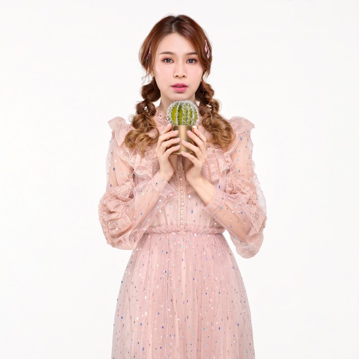 Asian woman with braided hair holding a cactus