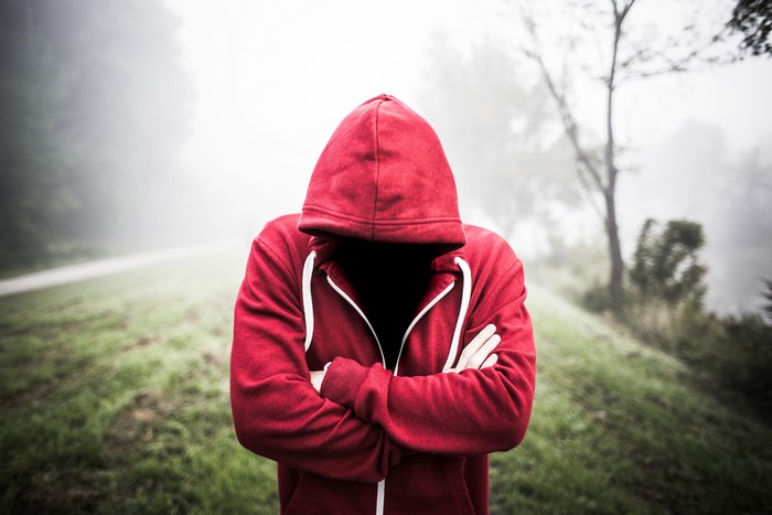 Man in red hoodie with arms crossed