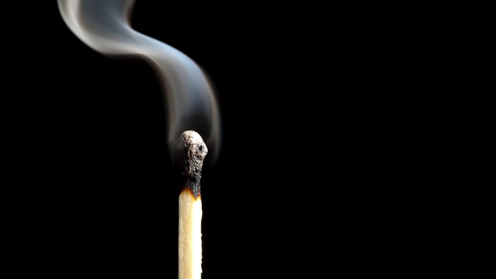 Close-up of a burning match with smoke