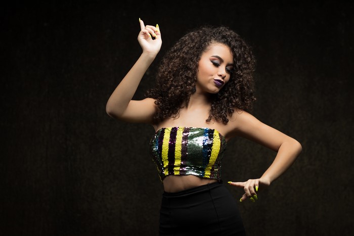 Camila with curly hair and manicure posing