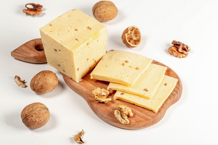 Cheese with walnuts on a cutting board