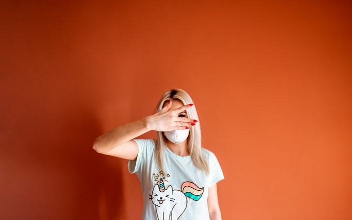 Blonde girl wearing a mask and t-shirt with unicorn cat