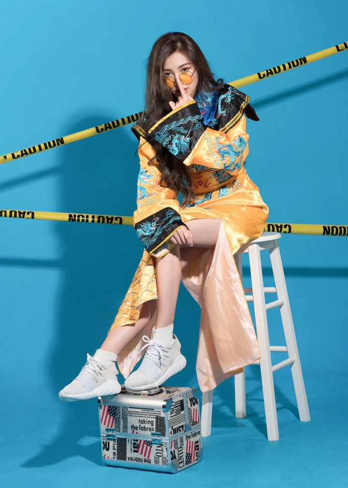 Woman in a yellow kimono sitting on a stool