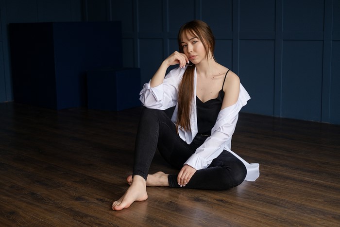 Liza sitting on the floor in jeans and singlet