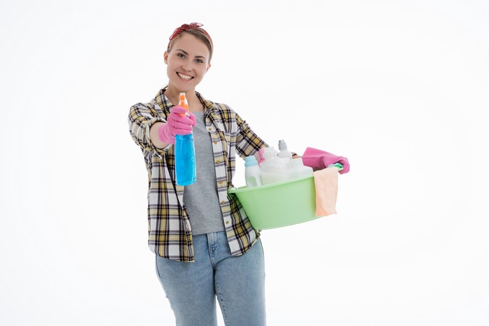 Woman with cleaning supplies on white background