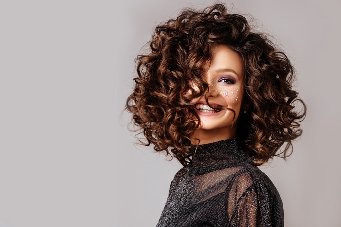 Beautiful woman with curly brown hair and makeup