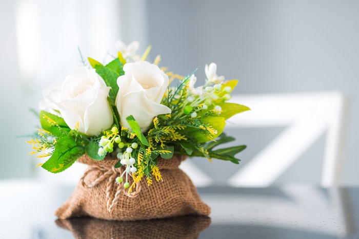 White Roses and Greenery in Burlap Vase