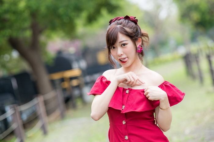 Asian woman in red dress with tongue out
