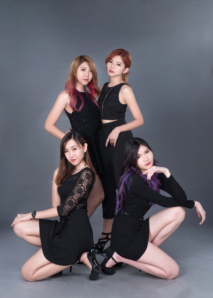 Four Asian women posing in black outfits