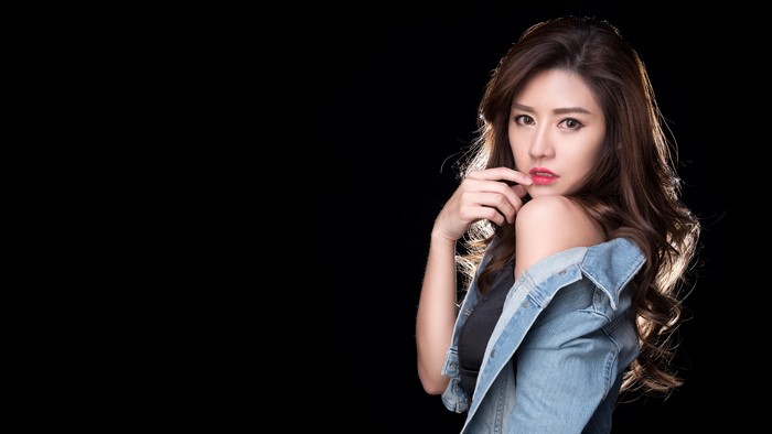 Asian woman with brown hair wearing a denim jacket
