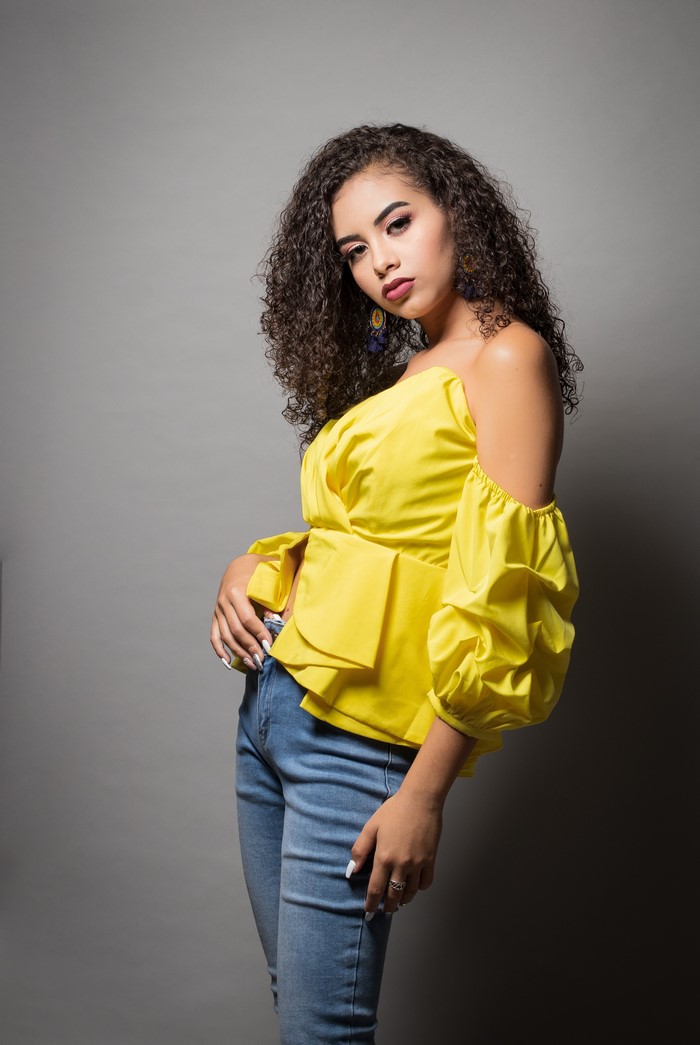 Camila wearing a yellow blouse and jeans
