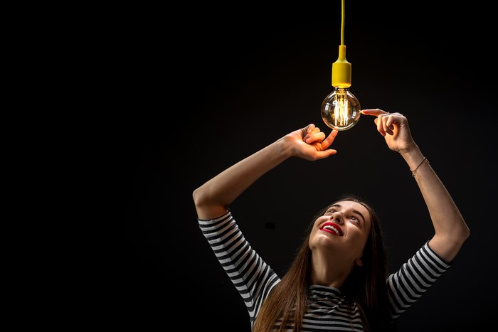Woman touching a light bulb