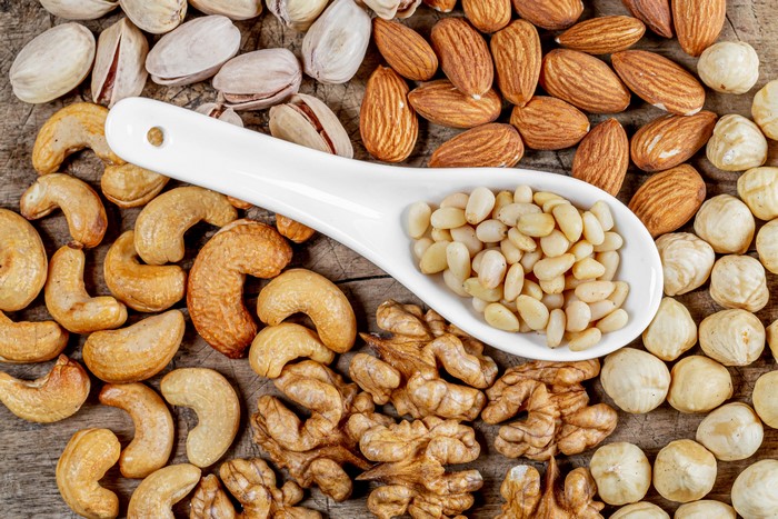 Assortment of Nuts on a Wooden Surface with Spoon