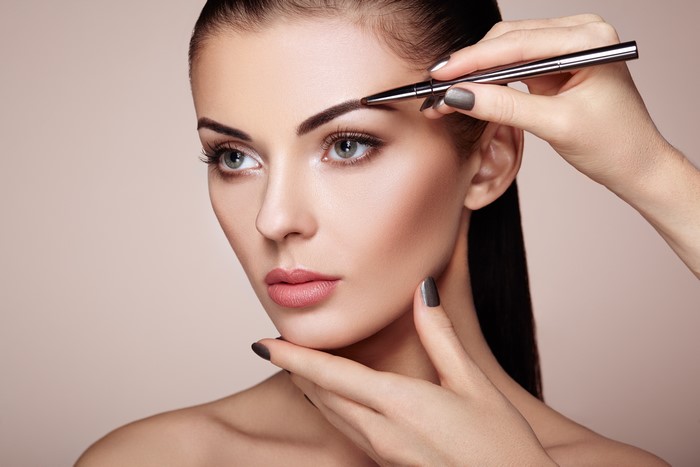 Model having eyebrows done with makeup