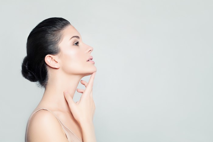 Brunette girl with makeup on gray background