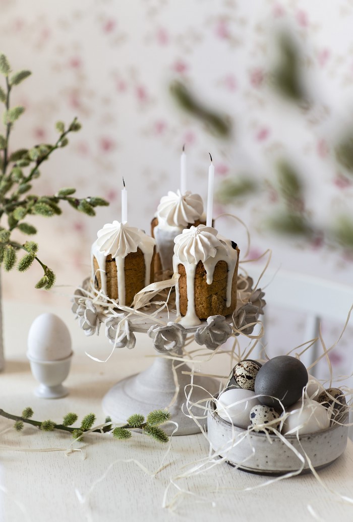 Easter cakes with candles and eggs on a table