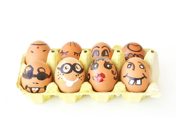 Easter eggs with faces in a carton