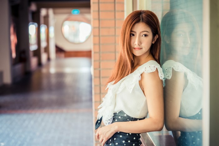 Asian woman with brown hair in a blouse and skirt