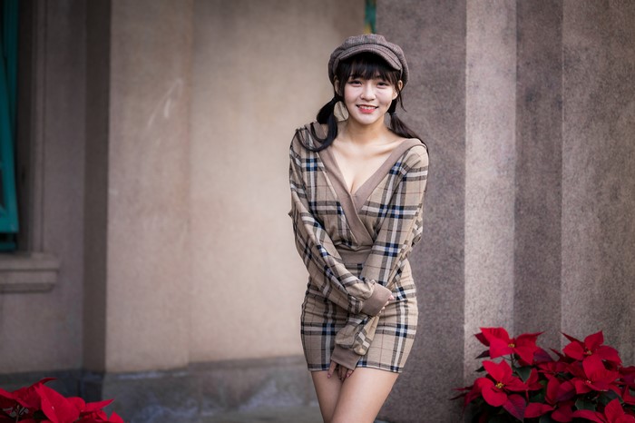 Asian woman in plaid dress and cap