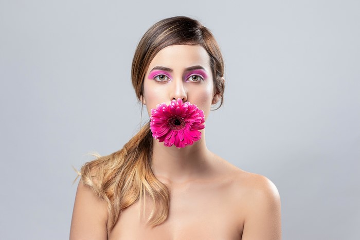 Woman with pink makeup and gerbera flower