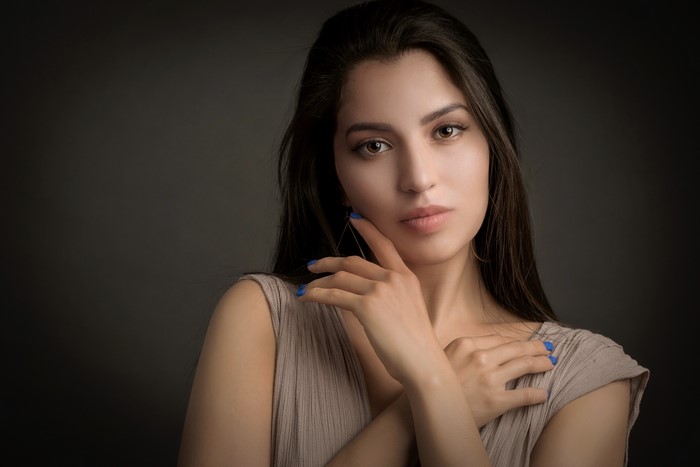 Woman with dark hair and blue nails
