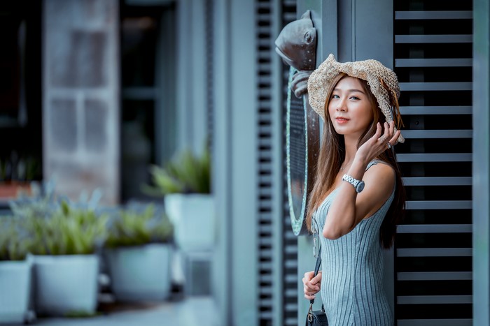 Asian woman with brown hair wearing a hat and dress