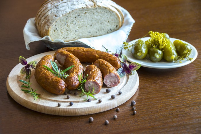 Sausage, Bread, Cucumbers, and Black Pepper on Cutting Board