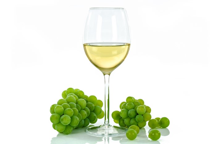 White wine in a glass with green grapes